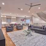 Modern Grey and White Open-Concept Living Room, Kitchen, and Dining Room Designs with Pops of Color in Florals and Wall Art