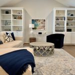 Coastal Cool Living Room Design with White Built-Ins, Blue Accents, Clear Acrylic Console Table, and Colorful Italian Art